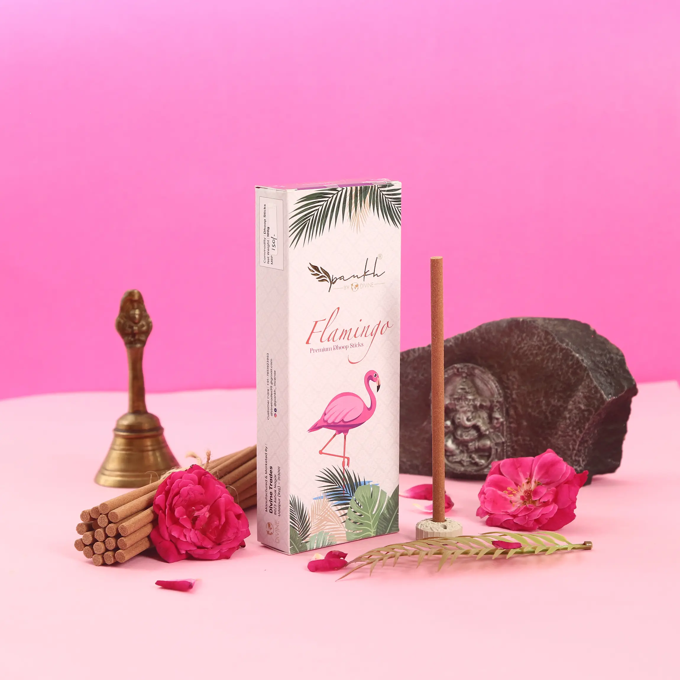 Pankh Flamingo incense box styled with brass bell and roses — lifestyle product photography